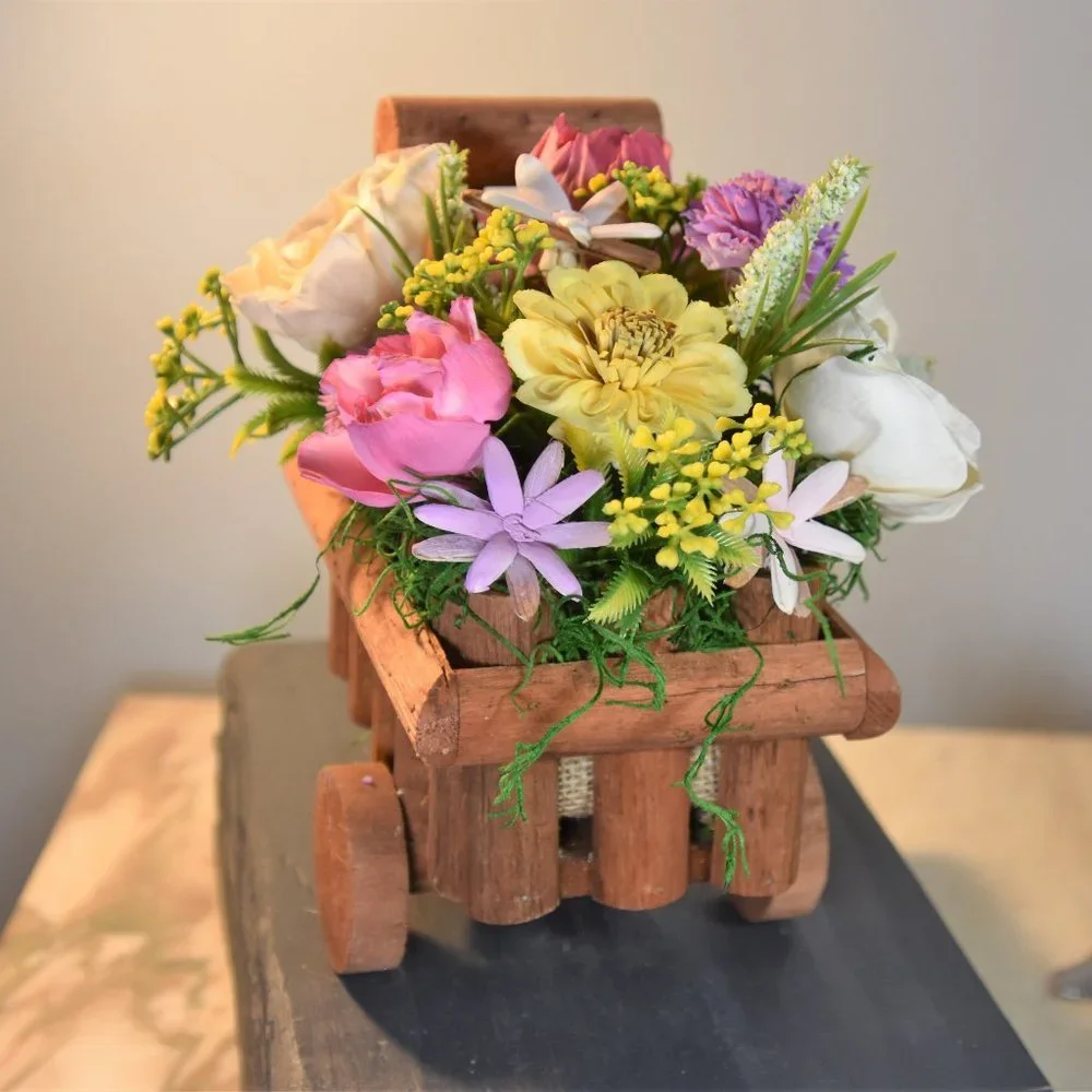 Cheerful garden arrangement of airbrushed Sola wood flowers in a garden cart